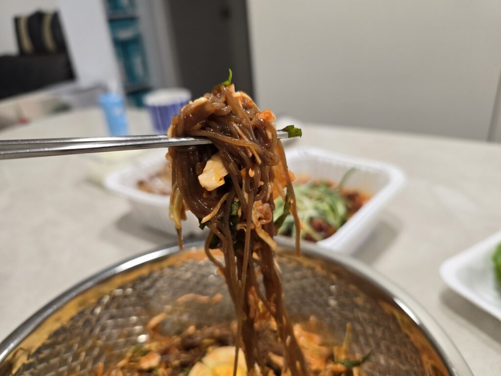 송강동 최군족발 쟁반국수 막국수를 먹으려고 한 젓가락 든 장면